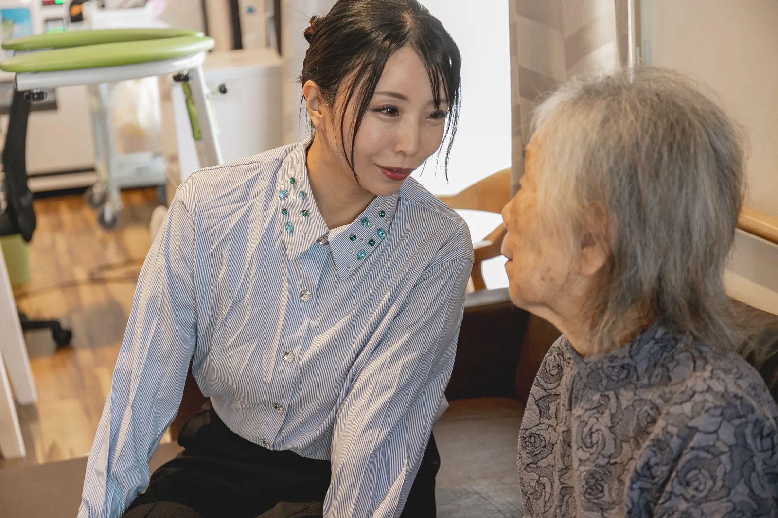 高齢の女性のそばで声をかける稲津